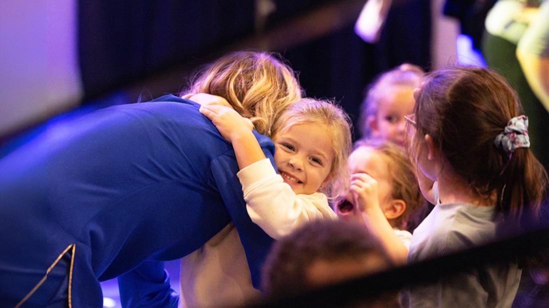Après le spectacle, Annabelle se penche vers les enfants qui la serrent dans leurs bras