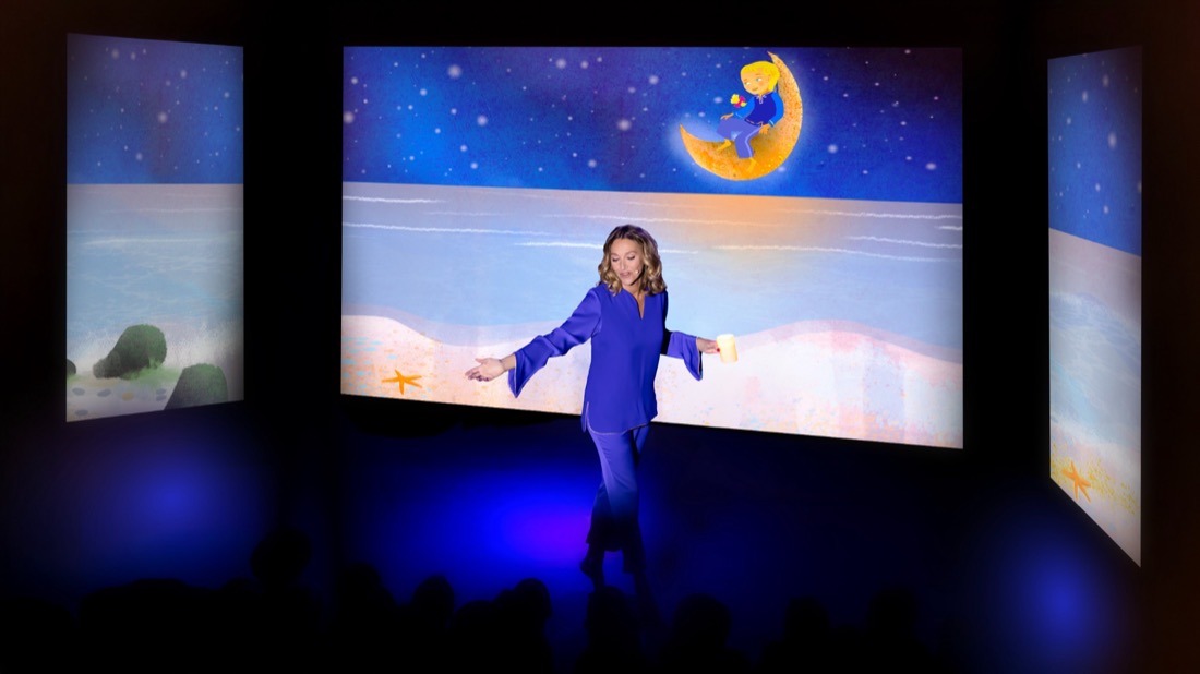 Sur scène, Annabelle danse devant trois écrans où se projette un paysage lunaire et étoilé